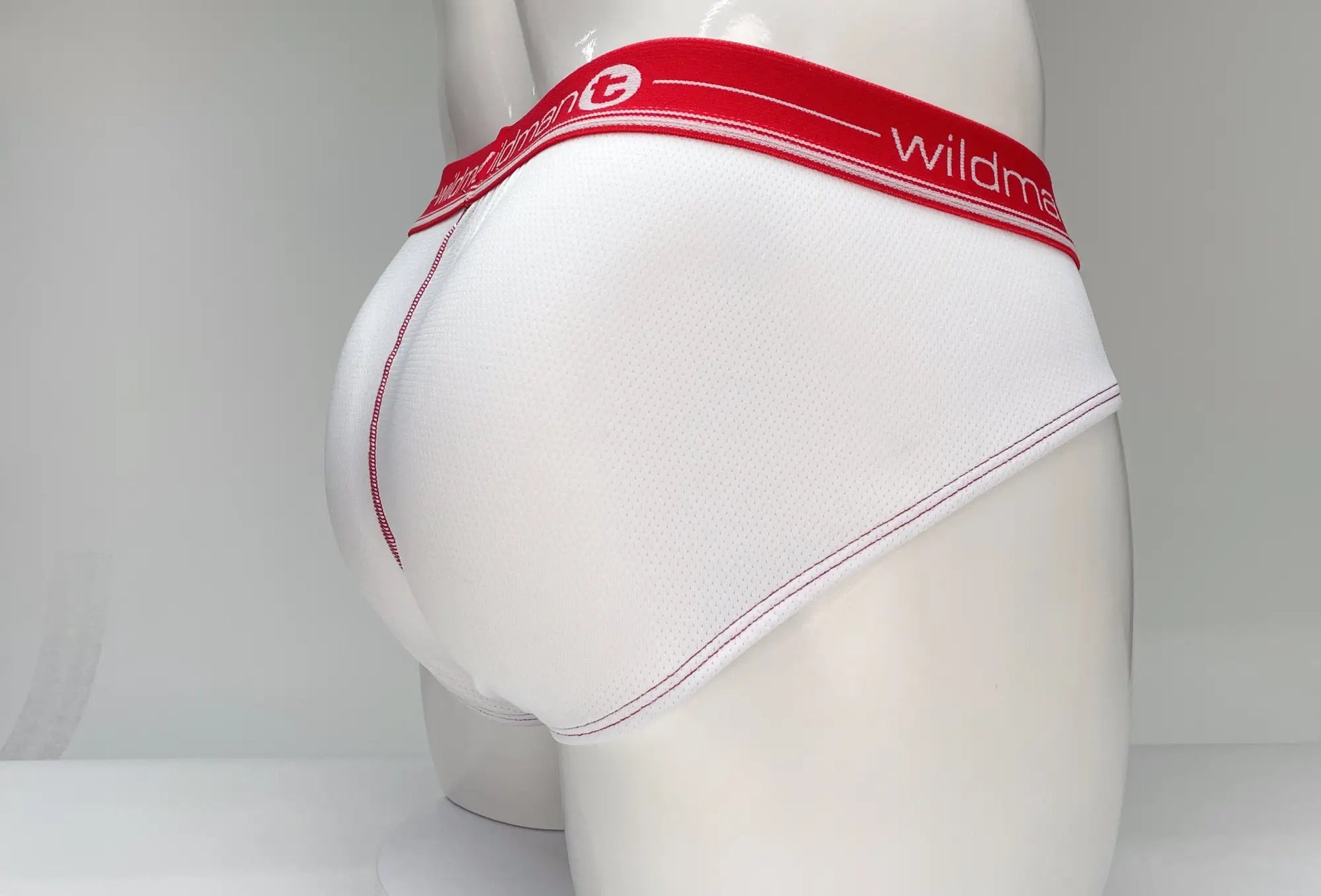 White mesh briefs with a red waistband featuring the wildman brand name and logo wildmant mesh brief white and red