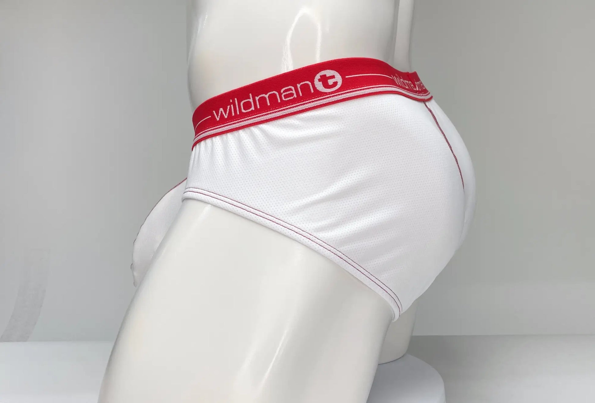 White mesh briefs with a red waistband featuring the Wildman brand logo for breathable comfort
