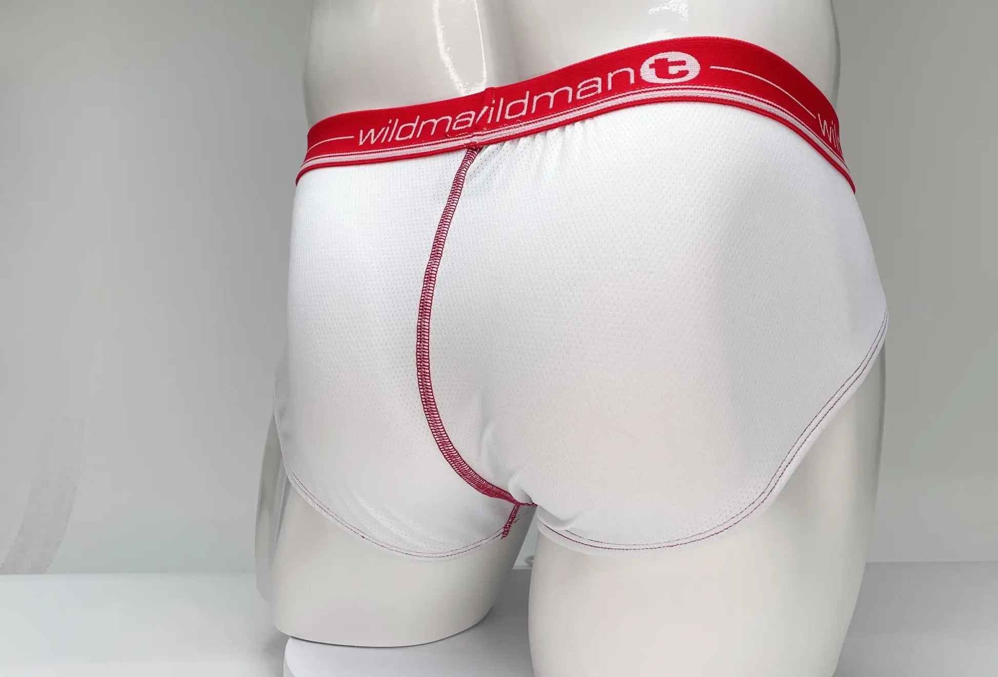 Wildmant mesh brief white and red with white fabric, red waistband featuring wildman logo, and pink stitching along seams