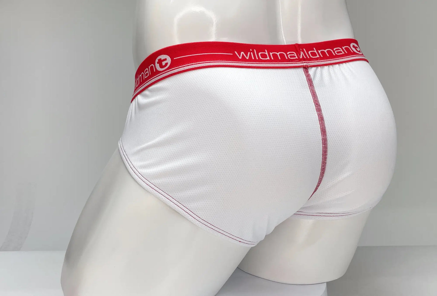 White wildman mesh brief underwear with red waistband striped with brand name and matching red stitching along seams