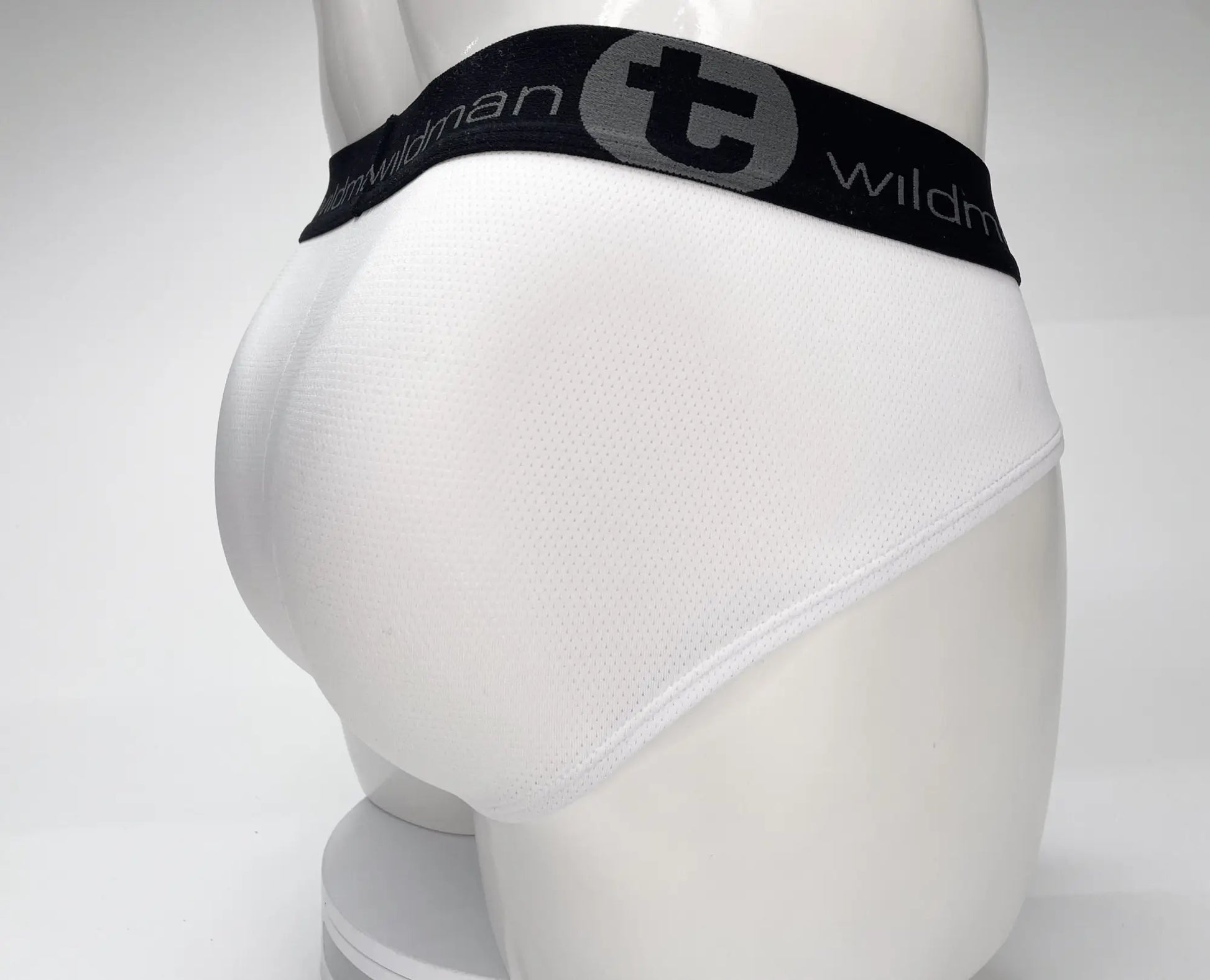 White WildmanT mesh monster cock brief with black elastic waistband featuring Wildman logo and gray circular emblem