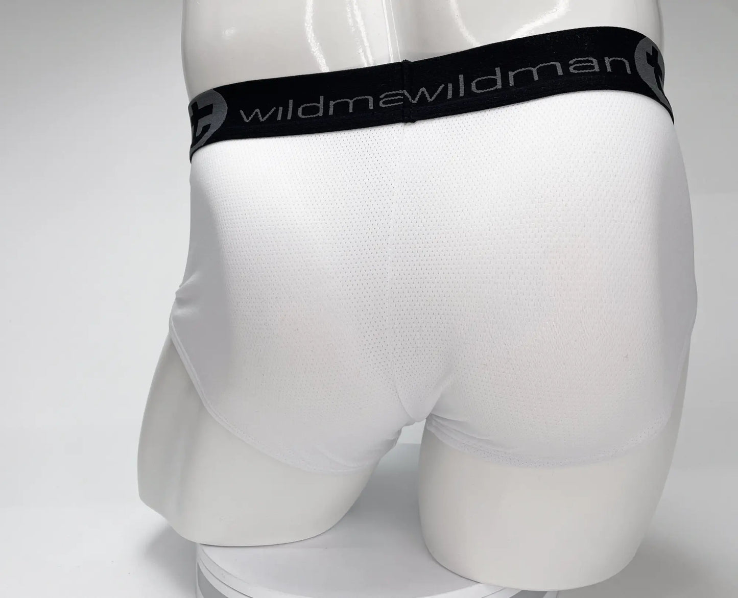 White men’s mesh briefs with black elastic waistband featuring wildman brand name for breathable comfort