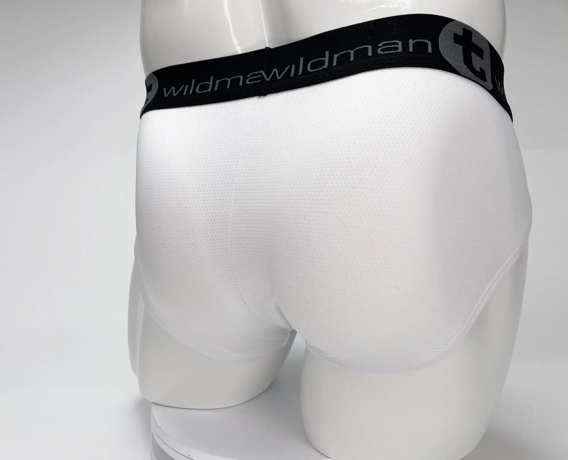 White men’s mesh briefs with a black elastic waistband featuring the wildman brand logo WildmanT Mesh Monster Cock Brief White