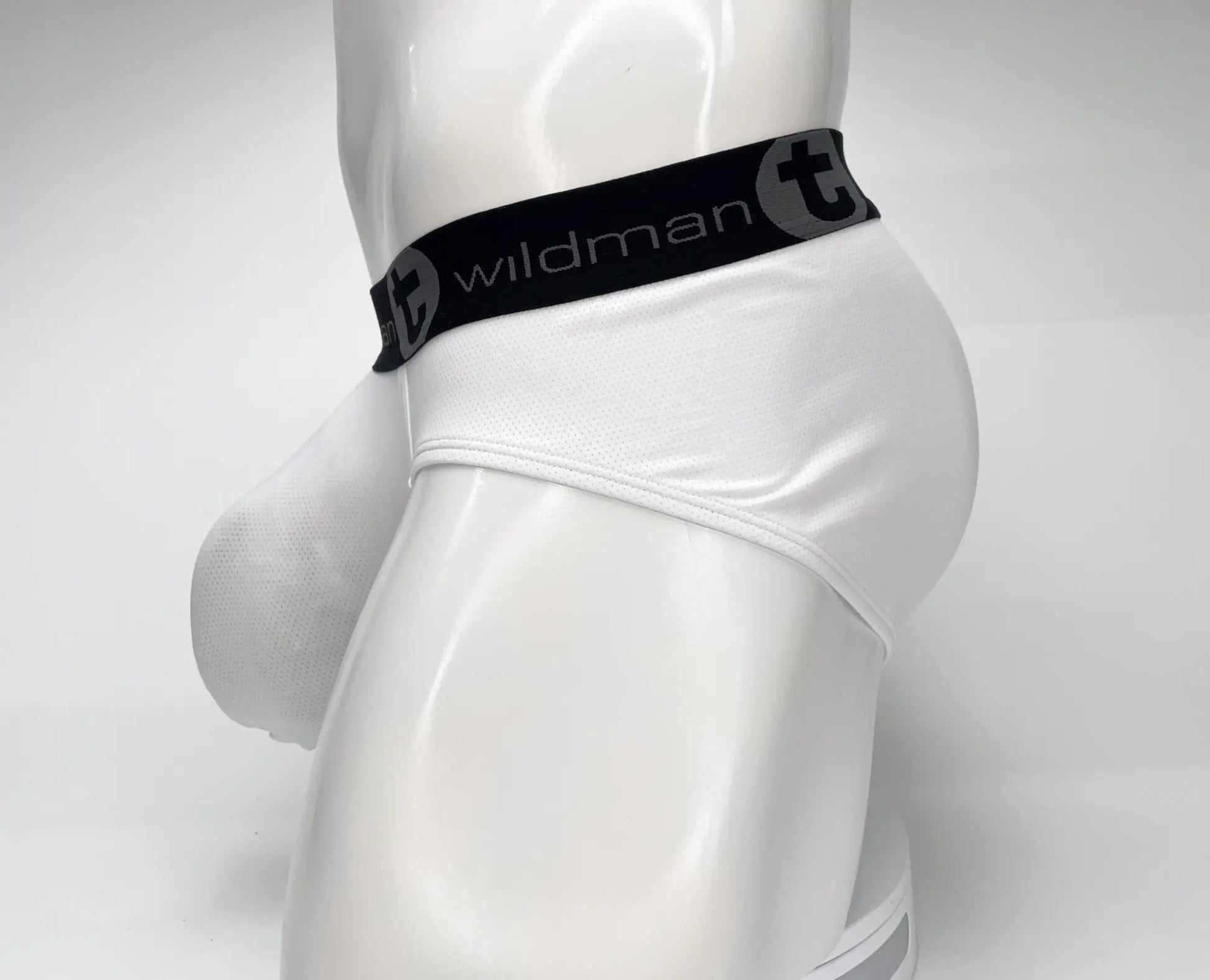 White wildman briefs with black elastic waistband featuring wildman logo in mesh monster cock brief style