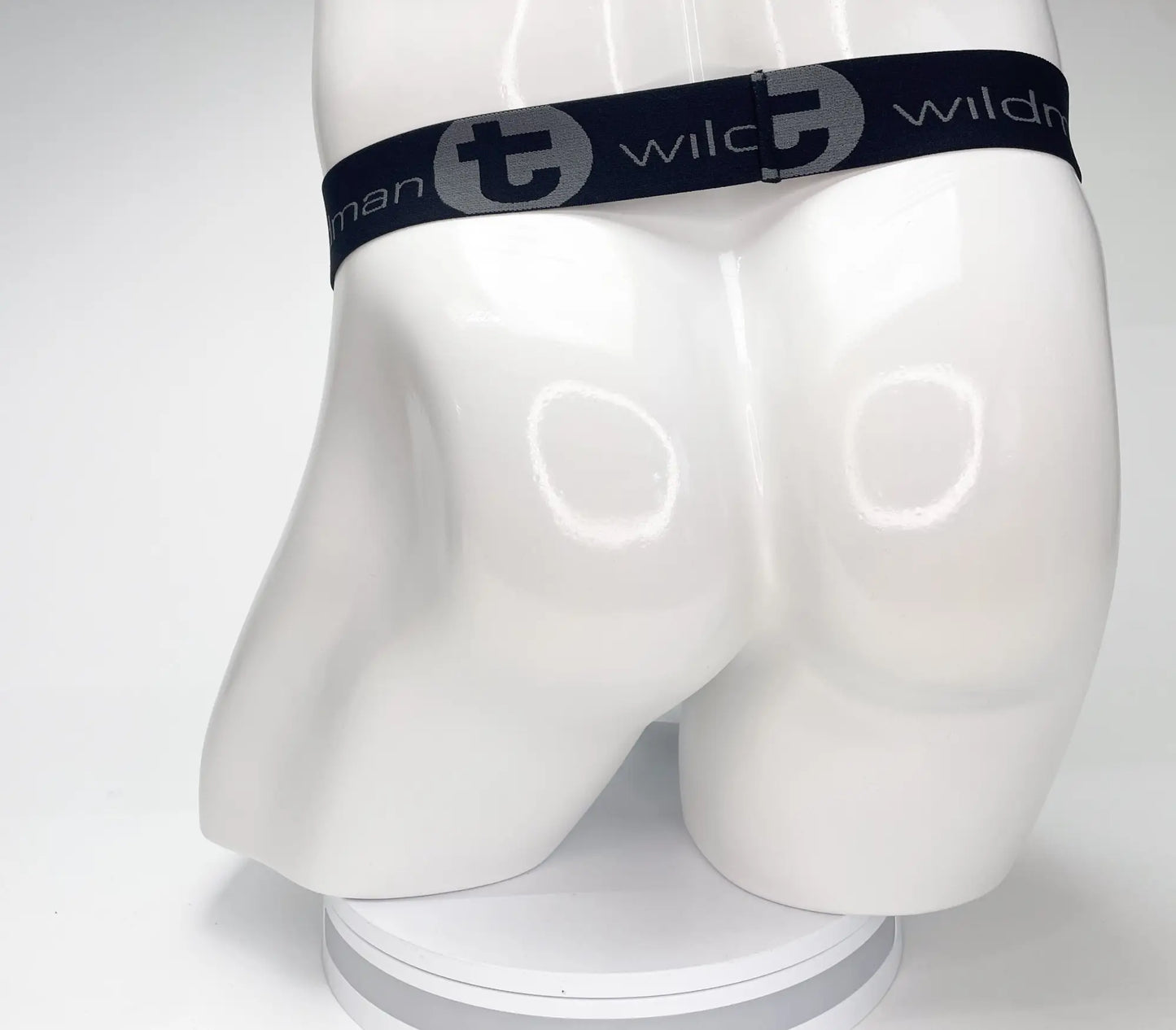 Black elastic waistband of wildmant mesh monster cock strapless pouch with gray logo and stylized t emblem