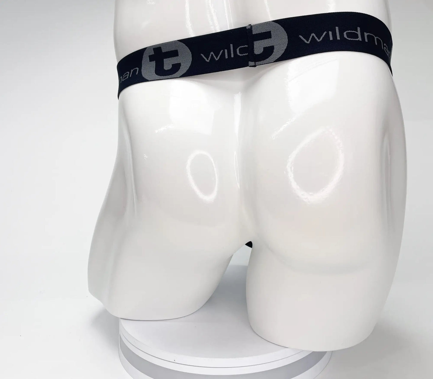 Black elastic waistband with gray wlc logo and wildman text on white mannequin for wildmant mesh monster cock strapless pouch black