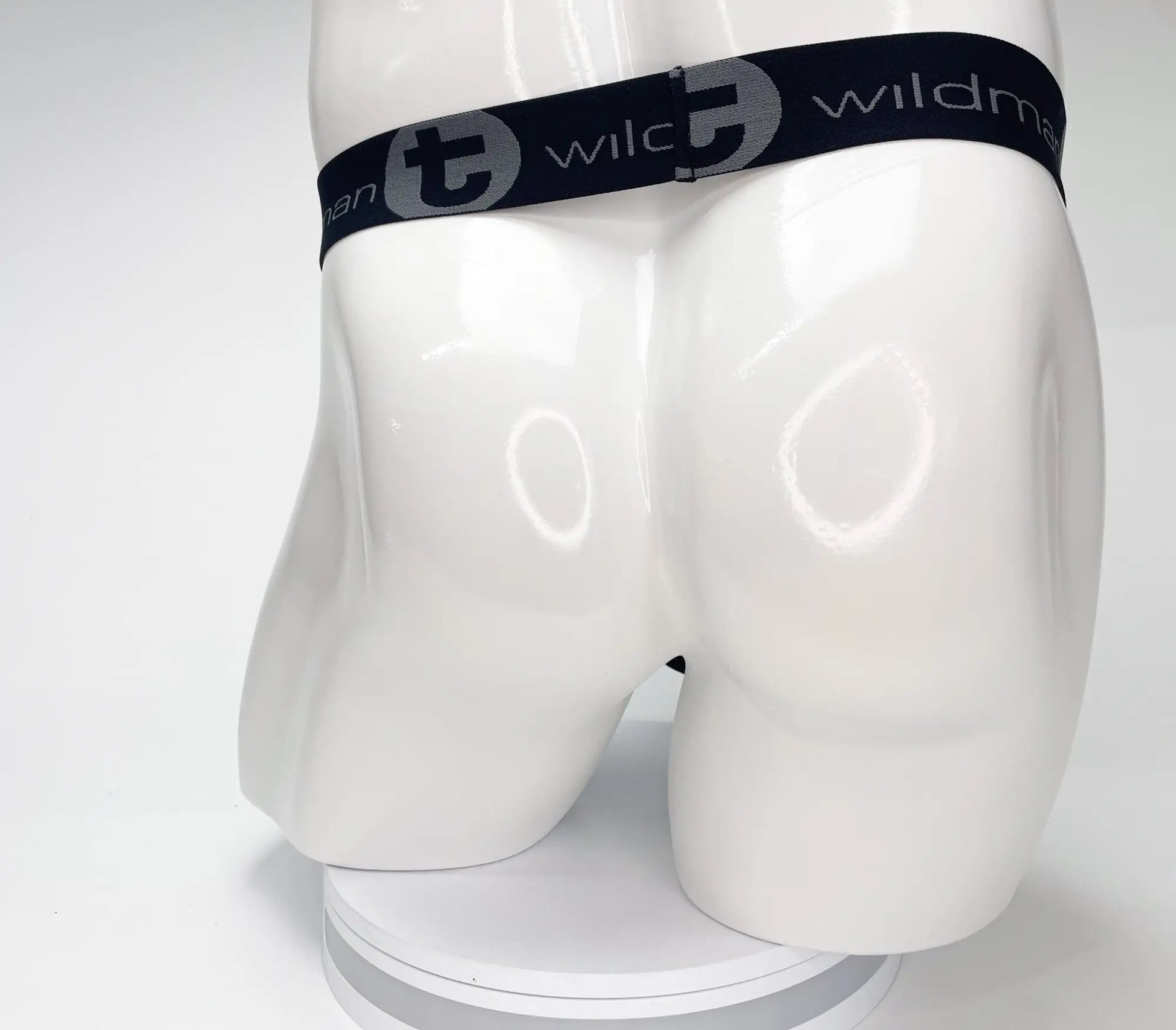 Black elastic waistband with gray wlc logo and wildman text on white mannequin for wildmant mesh monster cock strapless pouch black