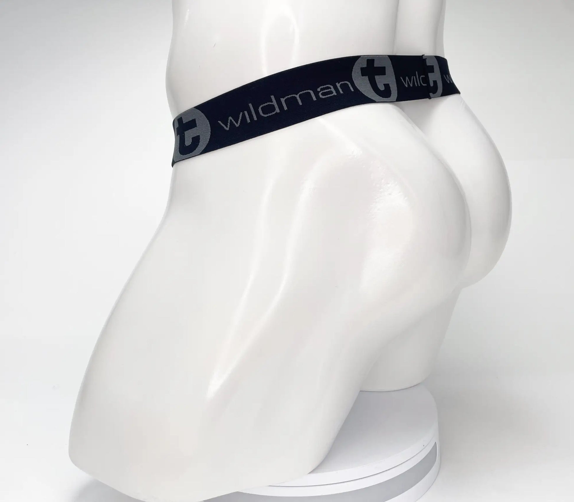 Black elastic waistband with wildman branding and circular logo on a wildmant mesh monster cock strapless pouch black displayed on a white mannequin