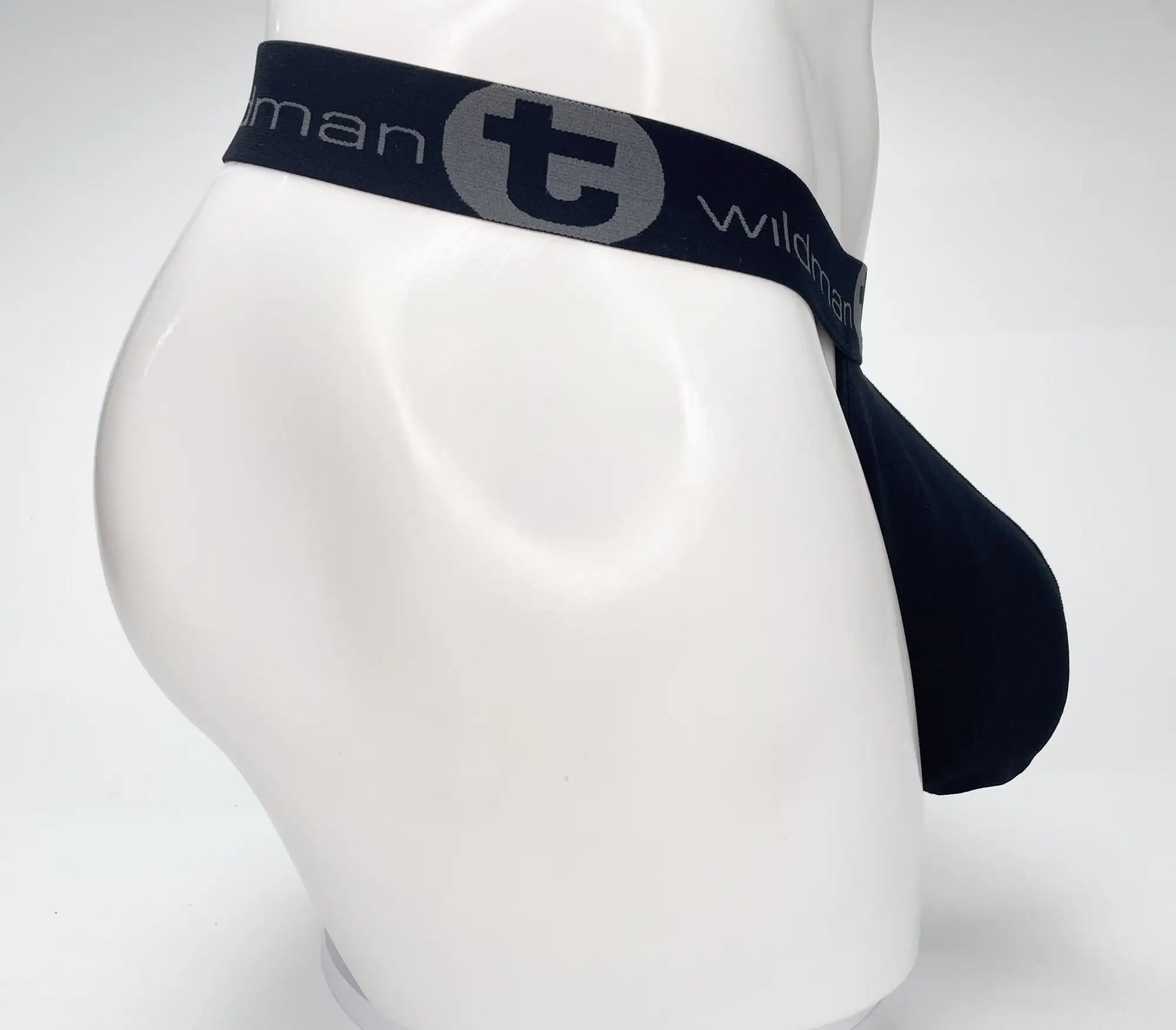 Black men’s briefs with navy elastic waistband featuring wildman logo in wildmant mesh monster cock strapless pouch black