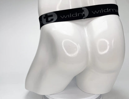 Black elastic waistband with wildman branding and circular logo on white mannequin wearing wildmant mesh monster cock strapless pouch white