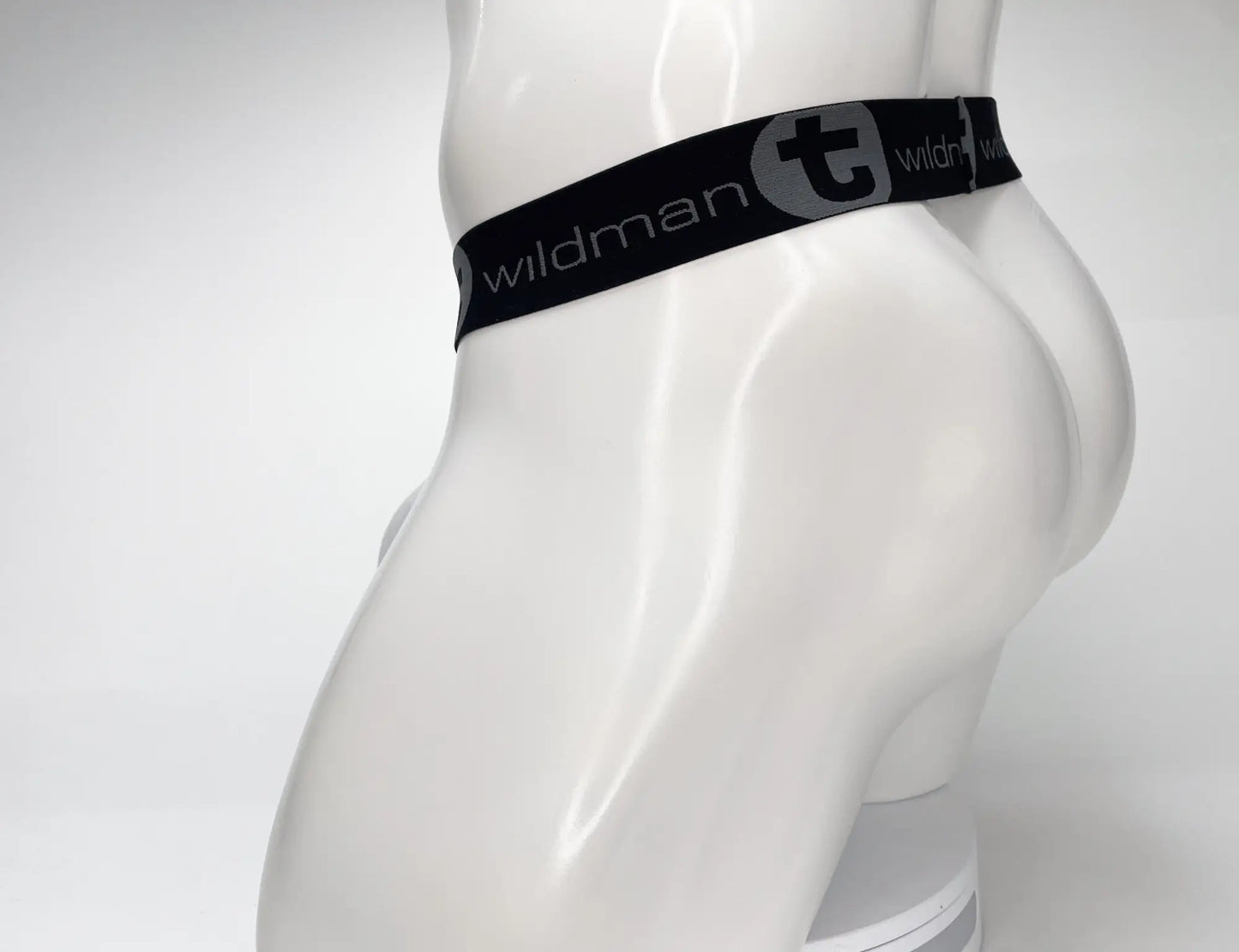 Black elastic waistband with wildman branding and gray stylized t logo on wildmant mesh monster cock strapless pouch white