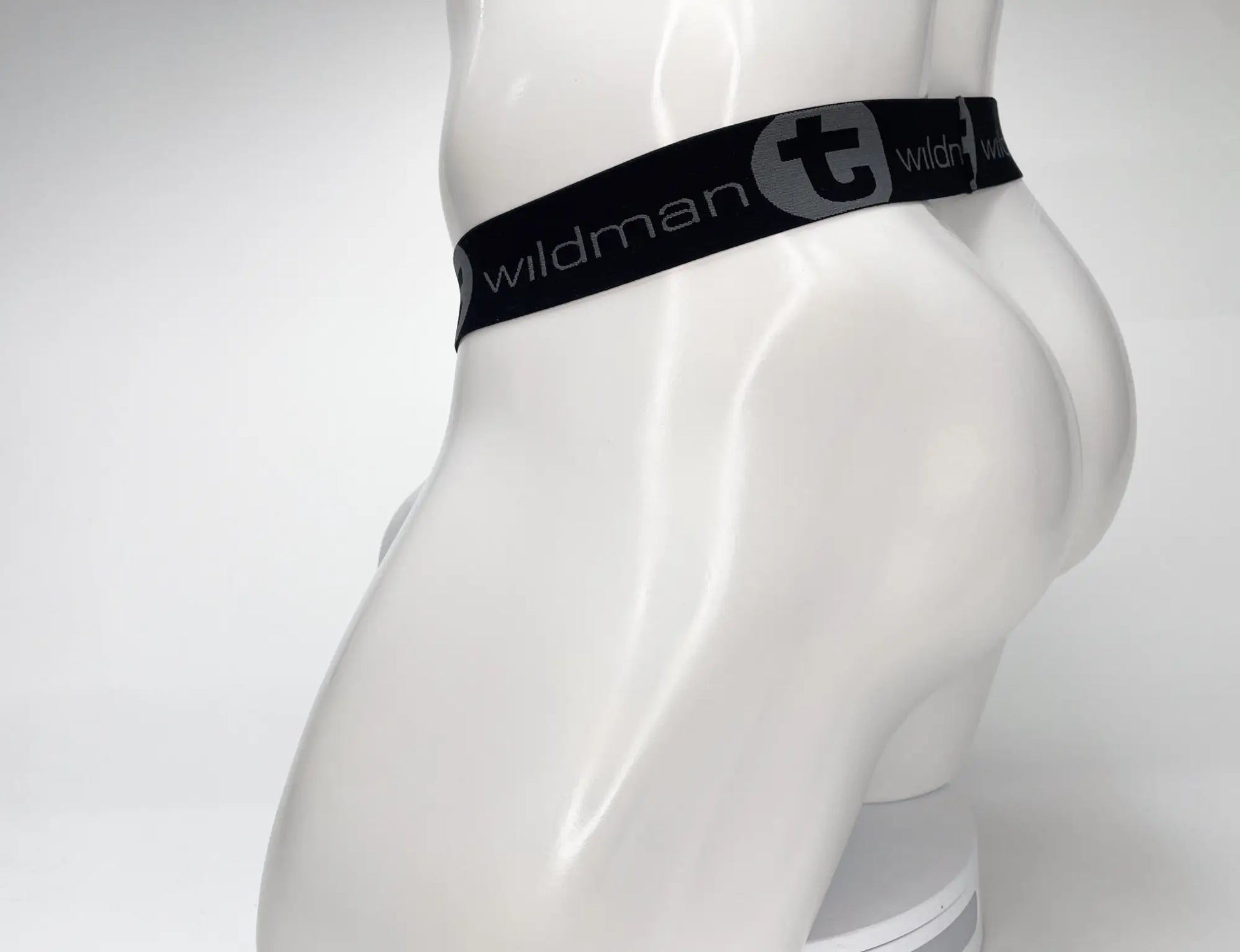 Black elastic waistband with wildman branding and gray stylized t logo on wildmant mesh monster cock strapless pouch white