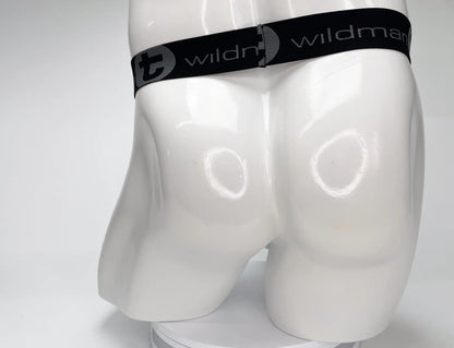 Black elastic waistband with wildman branding and stylized t logo on white mannequin of wildmant mesh monster cock strapless pouch