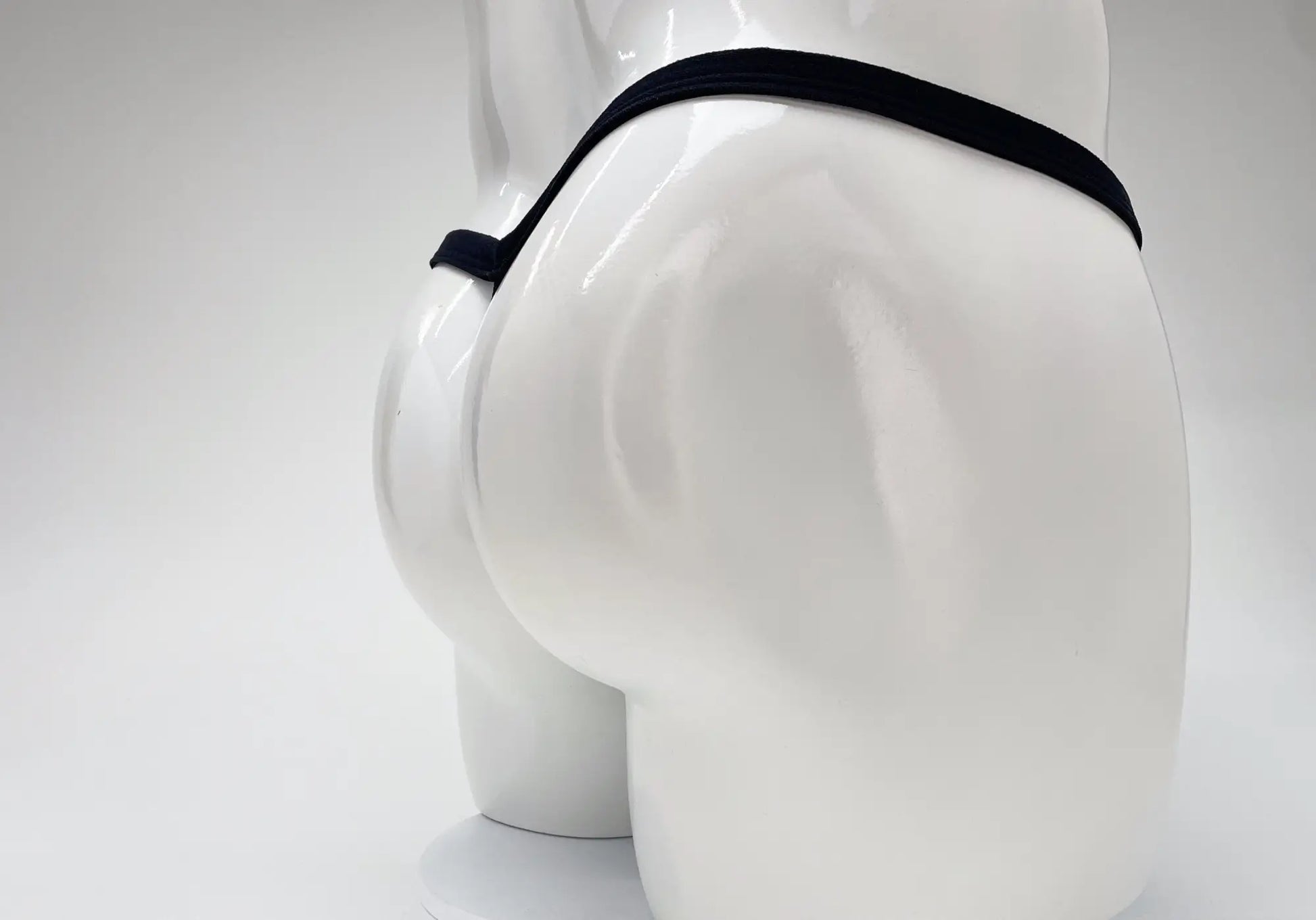 Black elastic waistband modal micro thong with big boy pouch displayed on white mannequin front view