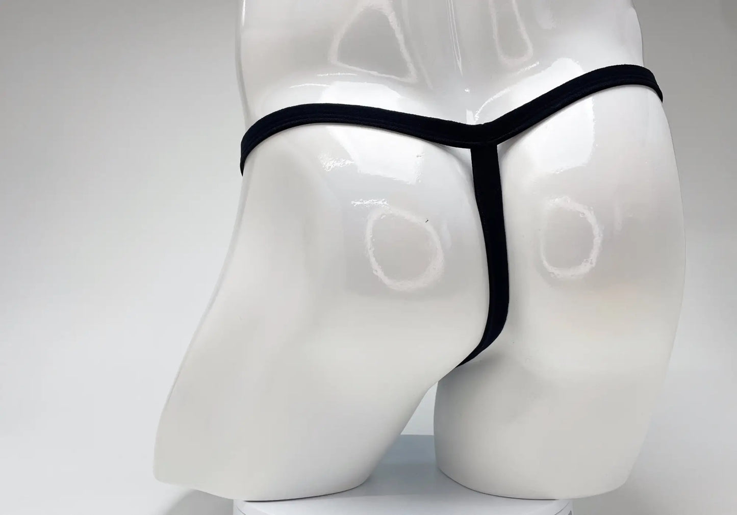 Black thong displayed on white mannequin highlighting wildmant modal micro thong big boy pouch in baby blue color