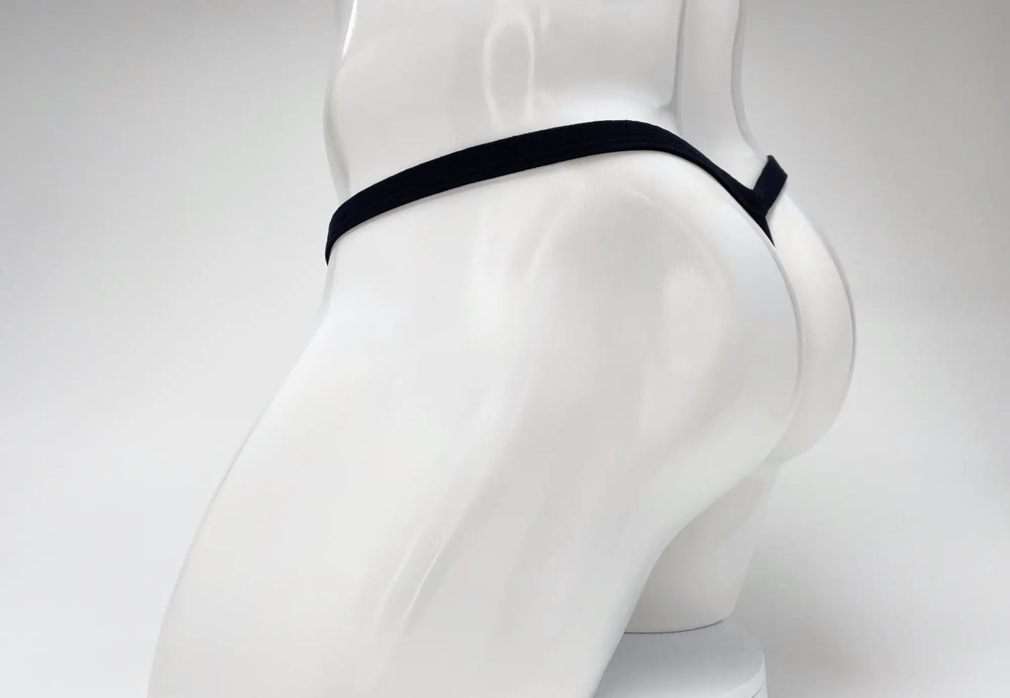 Black WildmanT modal micro thong on a white mannequin, showing the thin waistband and minimalist rear coverage.