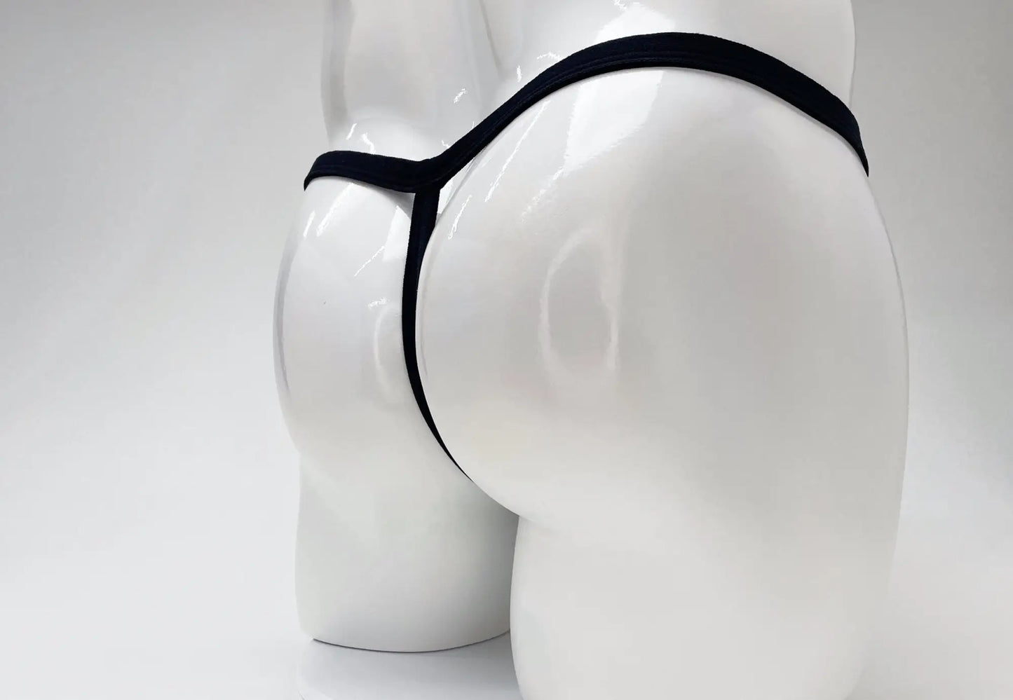 Black thong with big boy pouch in modal fabric displayed on white mannequin for wildmant product titled gold