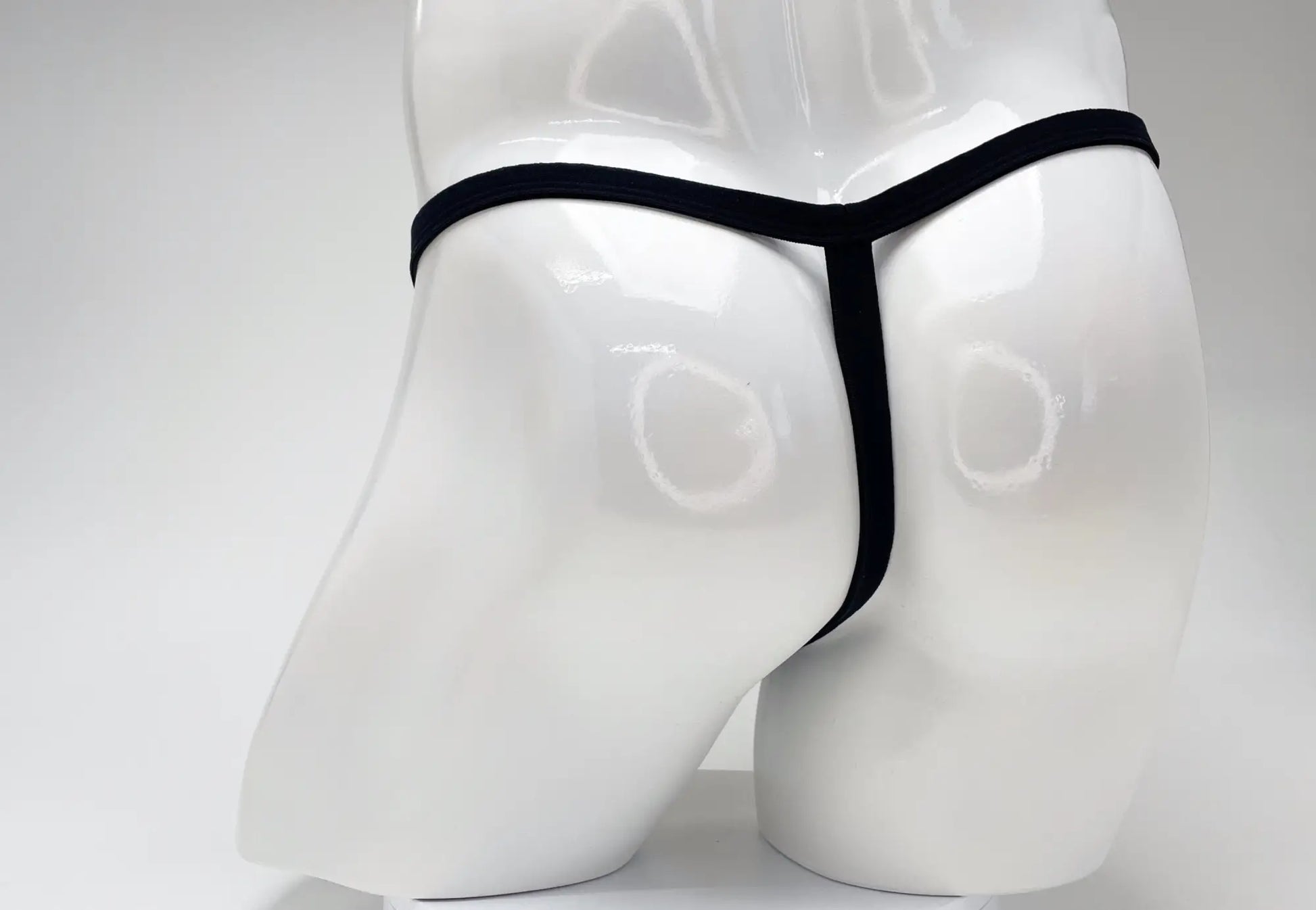 Black modal micro thong with big boy pouch displayed on white mannequin from wildmant product line