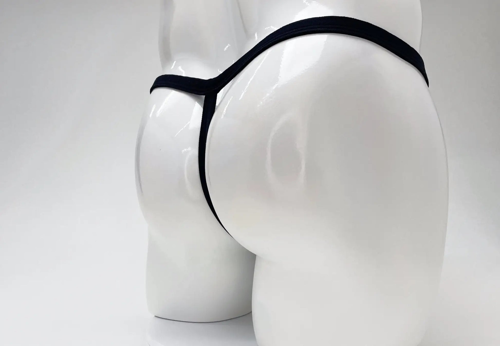 Black WildmanT modal micro thong on a white mannequin, showing a minimalist T-back design.