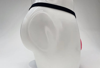 Pink WildmanT modal micro thong with a thin black waistband on a white mannequin torso.