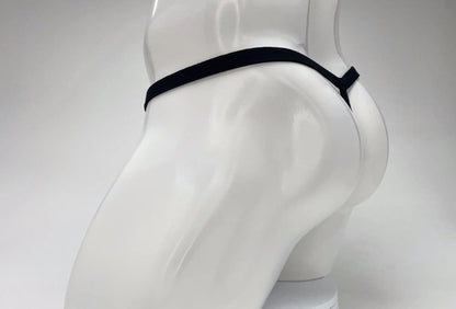 Black micro thong on a white mannequin, showing a minimalist string design from a side-rear perspective.