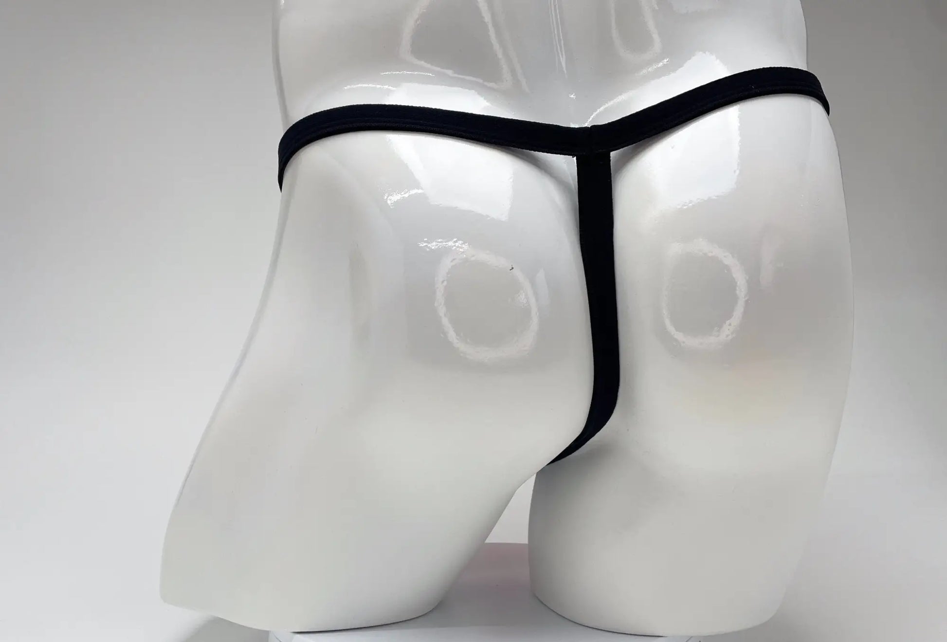 Black thong displayed on white mannequin featuring wildmant modal micro thong big boy pouch in pink
