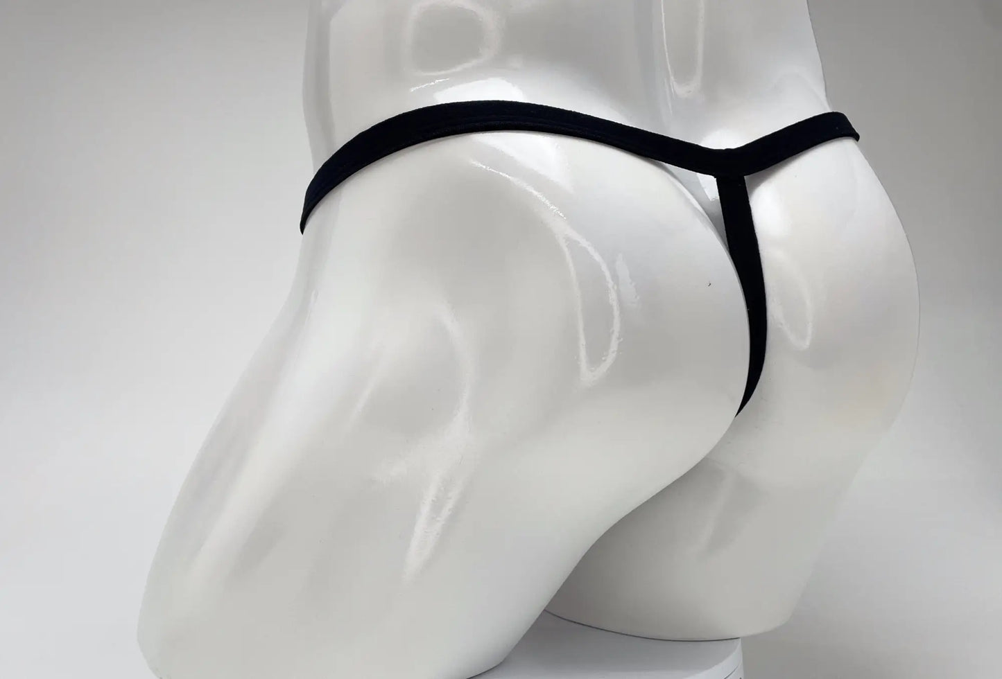 Black thong with big boy pouch displayed on white mannequin featuring wildmant modal micro thong pink material