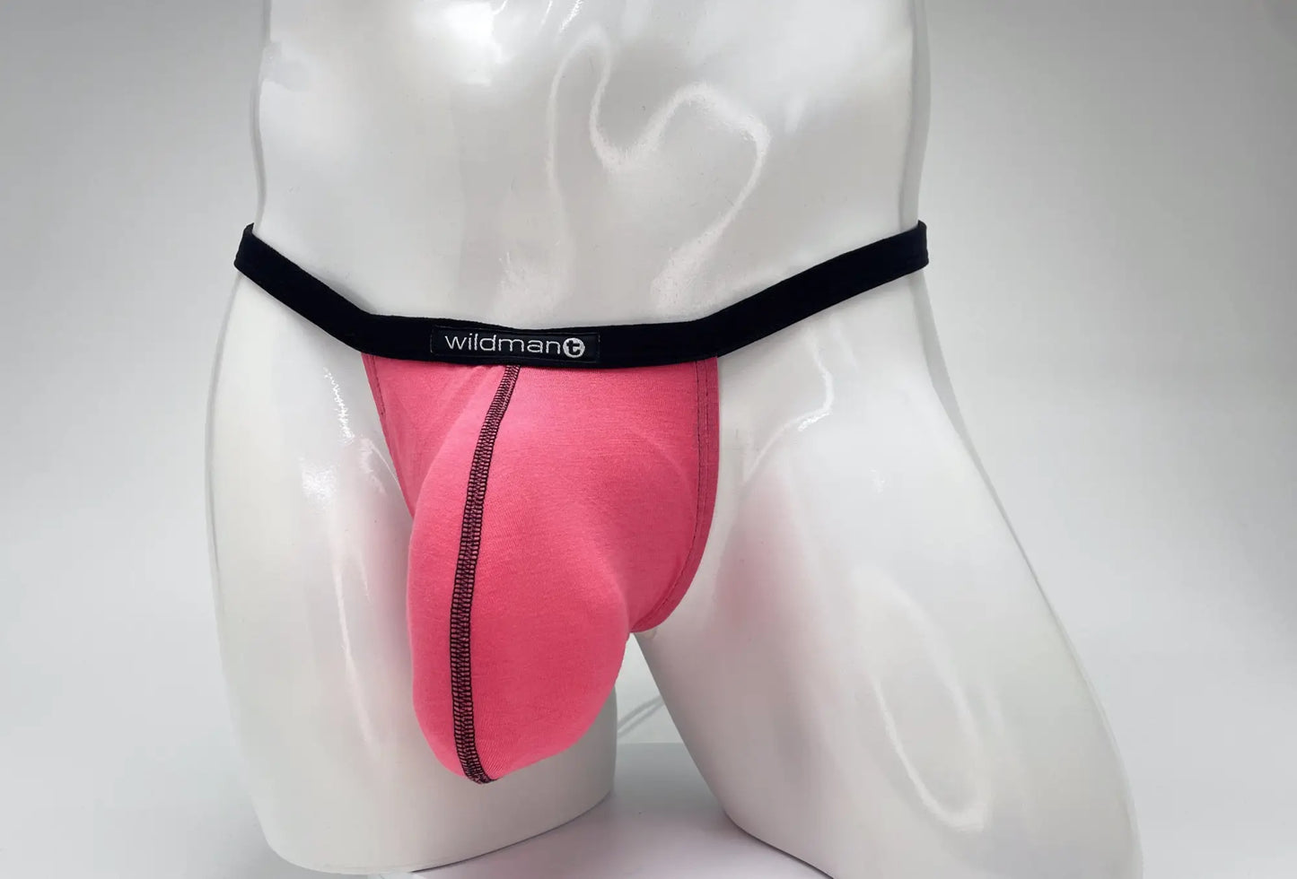 Pink WildmanT modal micro thong with a prominent pouch, black waistband, and visible black contrast stitching.