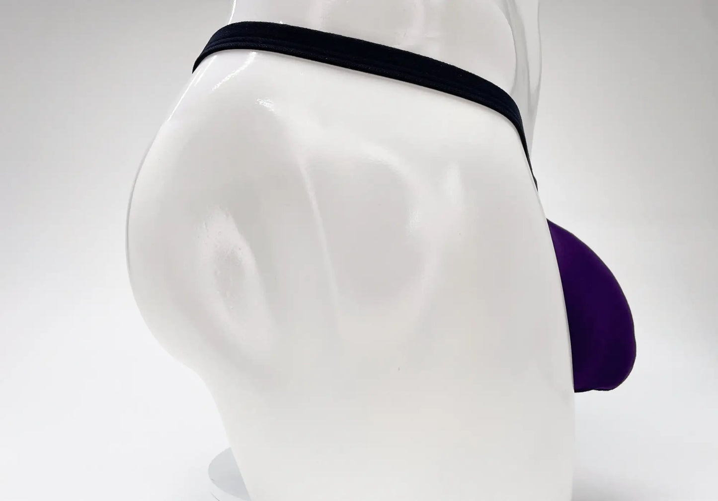 Purple and black wildmanT modal micro thong with big boy pouch displayed on a mannequin front side