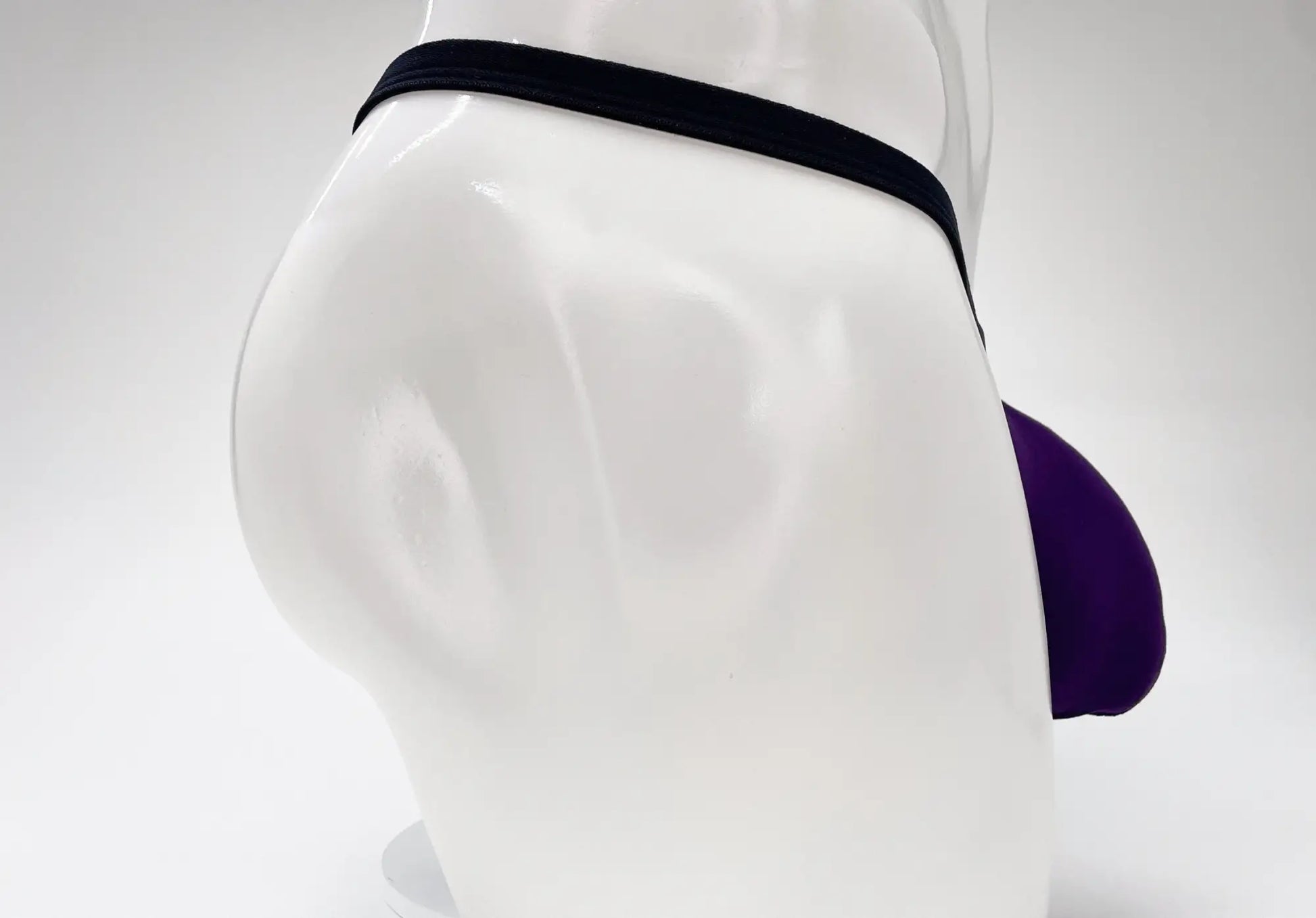 Purple and black wildmanT modal micro thong with big boy pouch displayed on a mannequin front side