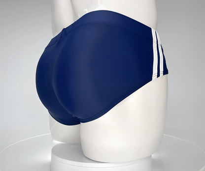 Wildmant monster cock swim brief navy featuring navy blue swim trunks with three white stripes on the side