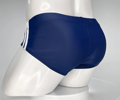 Wildmant monster cock swim brief navy blue swim trunks with three white side stripes displayed on mannequin