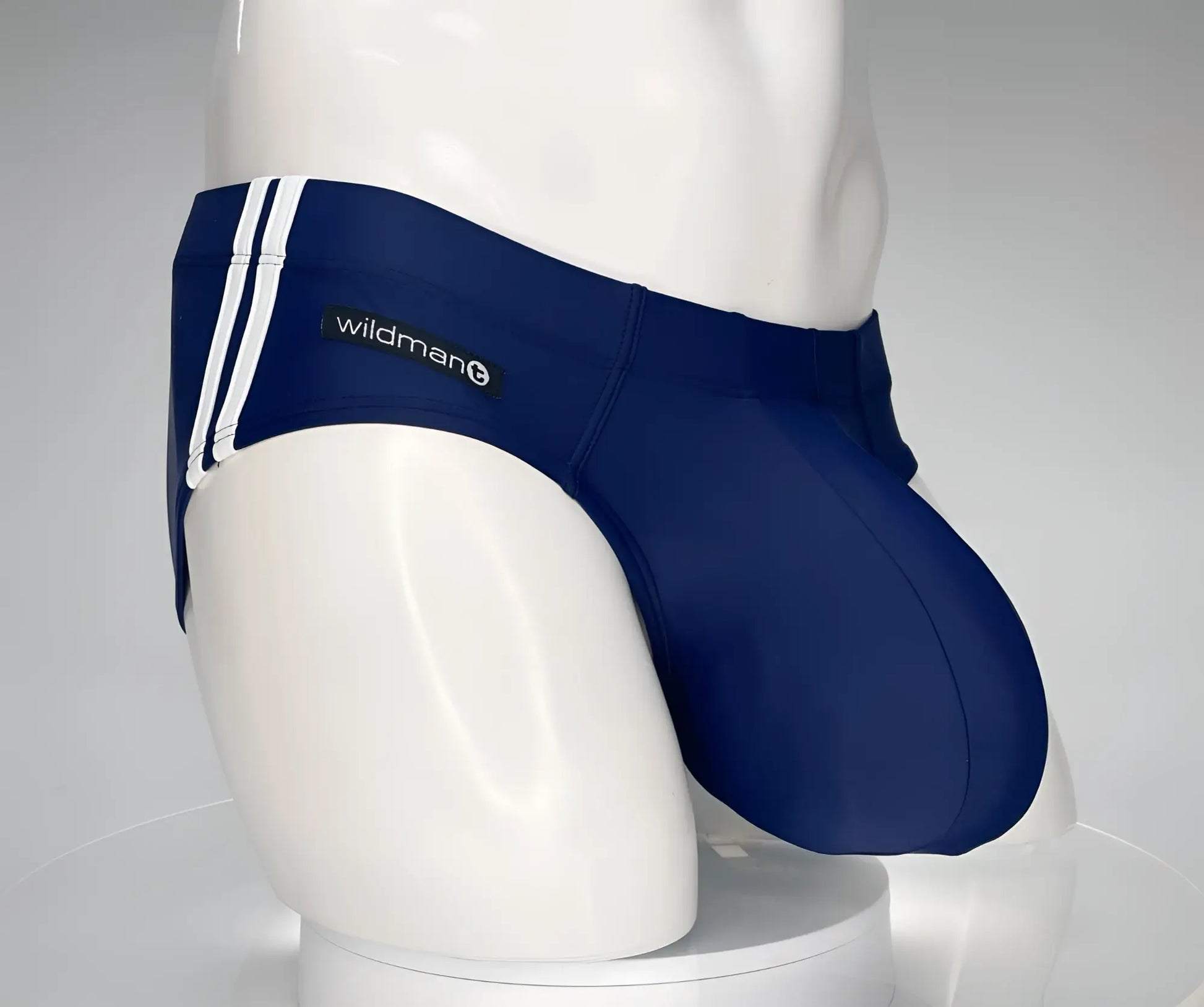 Navy blue WildmanT Monster Cock swim brief with white side stripes and wildman logo on the waistband