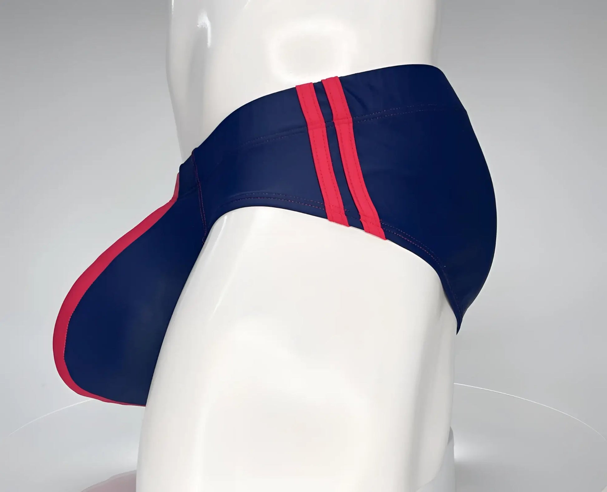 Navy blue wildmant monster cock swim brief with bold red side stripes designed for swimming and beachwear