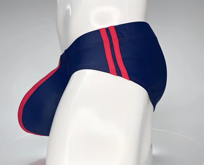 Navy blue wildmant monster cock swim brief with bold red side stripes designed for swimming and beachwear