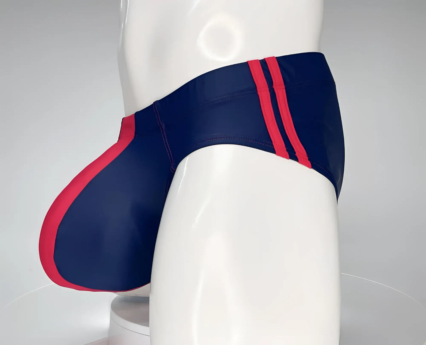 WildmanT Monster Cock navy swim brief with bold red side stripes and matching red leg seam accent