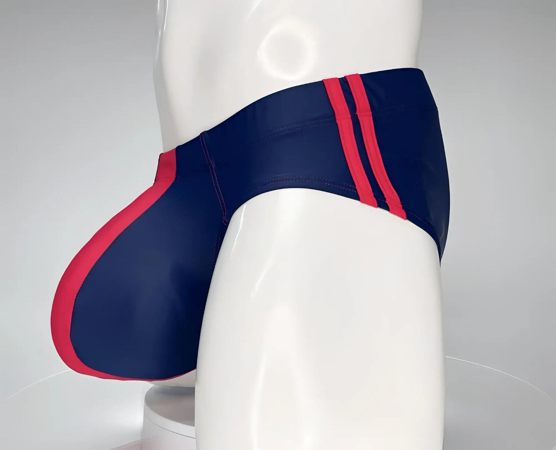 WildmanT Monster Cock navy swim brief with bold red side stripes and matching red leg seam accent