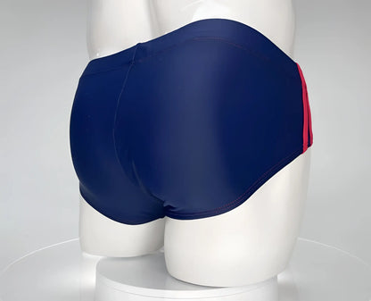Wildmant monster cock swim brief in navy blue with a red side stripe designed for swimming and beachwear