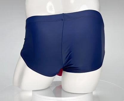 Back view of wildmant monster cock swim brief navy red in navy blue glossy fabric with center back seam