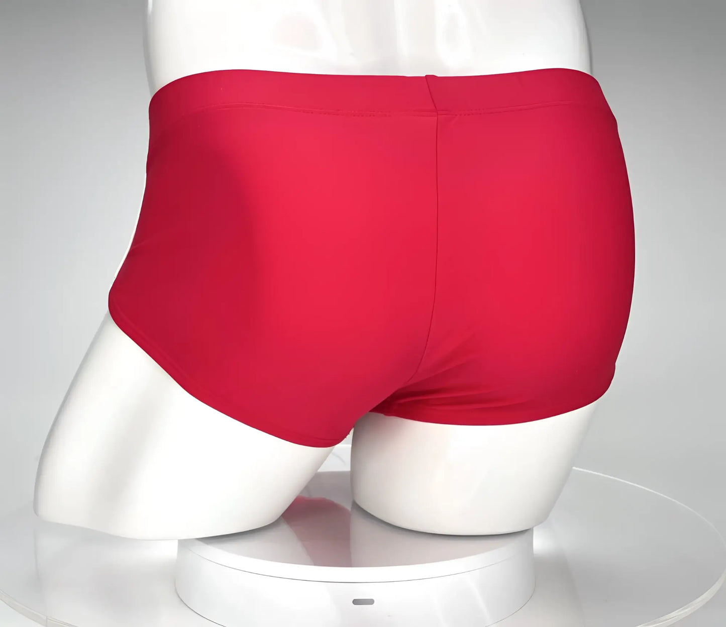Bright red smooth-textured WildmanT monster cock swim brief displayed on a mannequin for swimming and beachwear