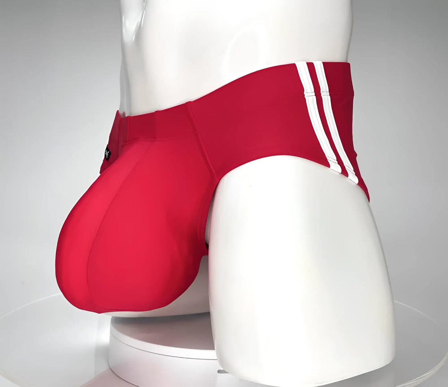 WildmanT Monster Cock swim brief red in red with three white stripes on the side displayed on a mannequin