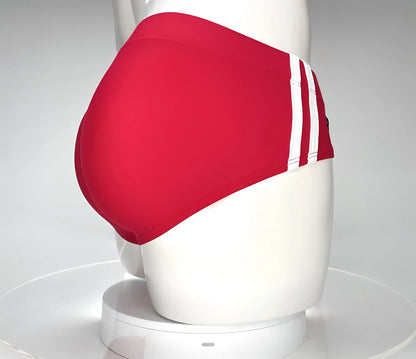 Red swim trunks WildmanT Monster Cock swim brief with three white side stripes displayed on a mannequin front view