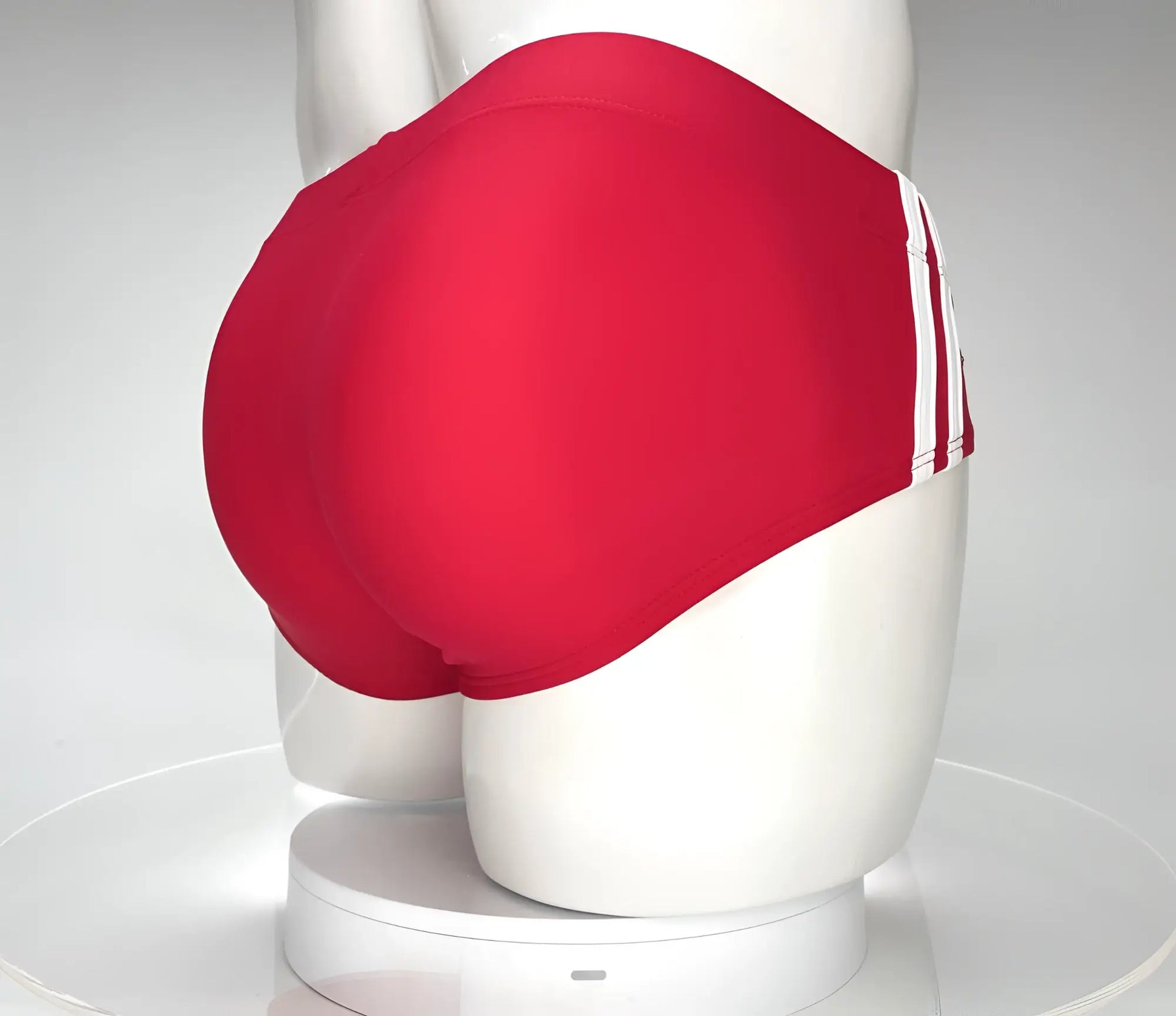 WildmanT Monster Cock swim brief red featuring red swim trunks with three white side stripes on a mannequin