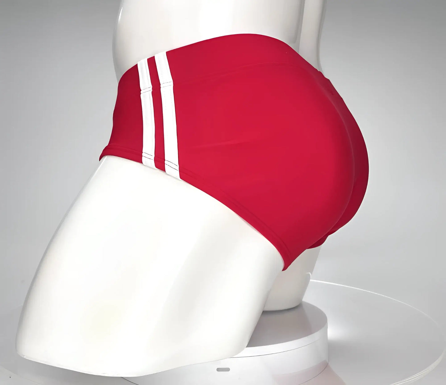 WildmanT Monster Cock swim brief red with three white stripes on the side displayed on a mannequin