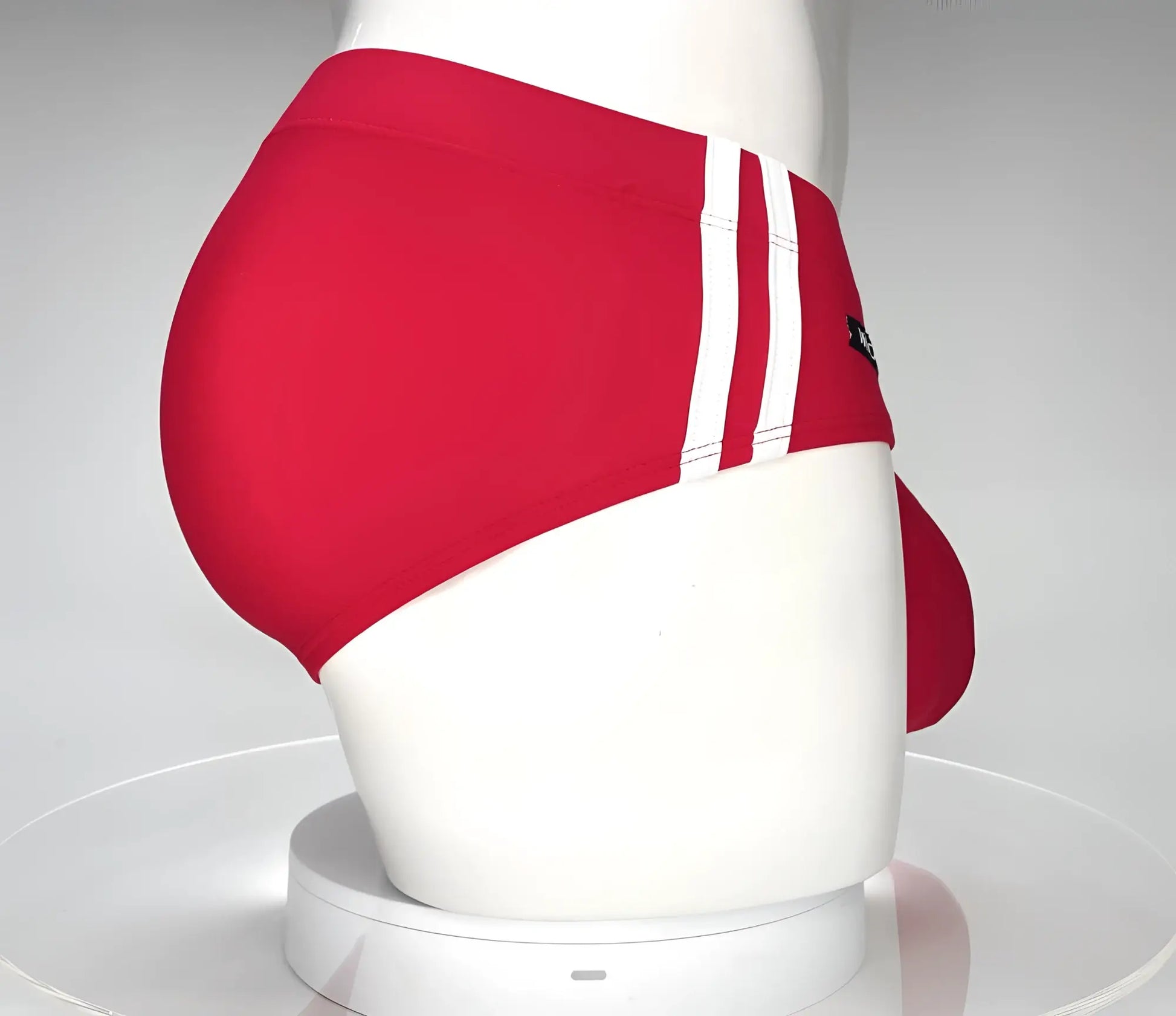 WildmanT monster cock swim brief in red with three white stripes and black logo on the side for swimming use