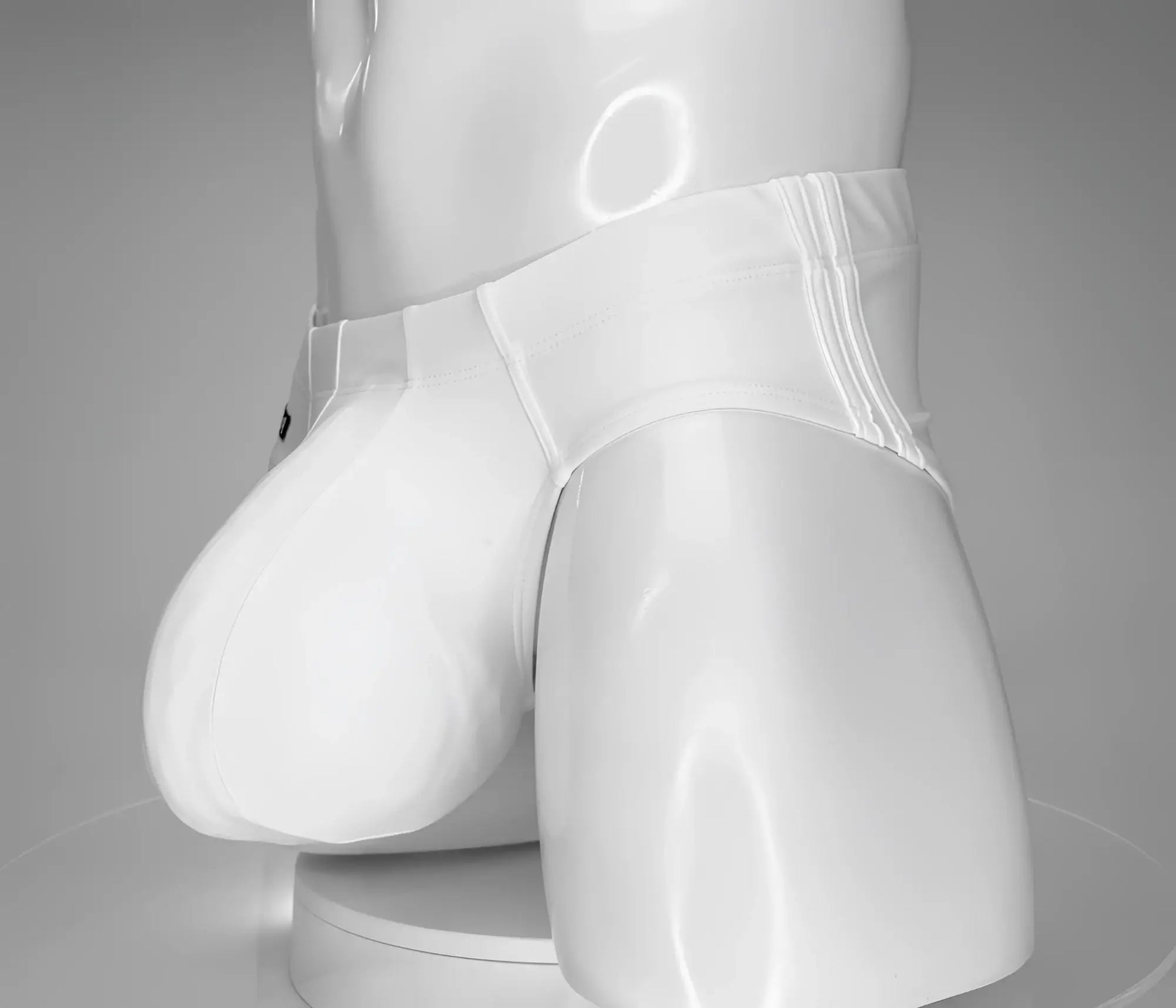 WildmanT monster cock swim brief white glossy latex briefs with smooth shiny surface and subtle vertical seam detailing