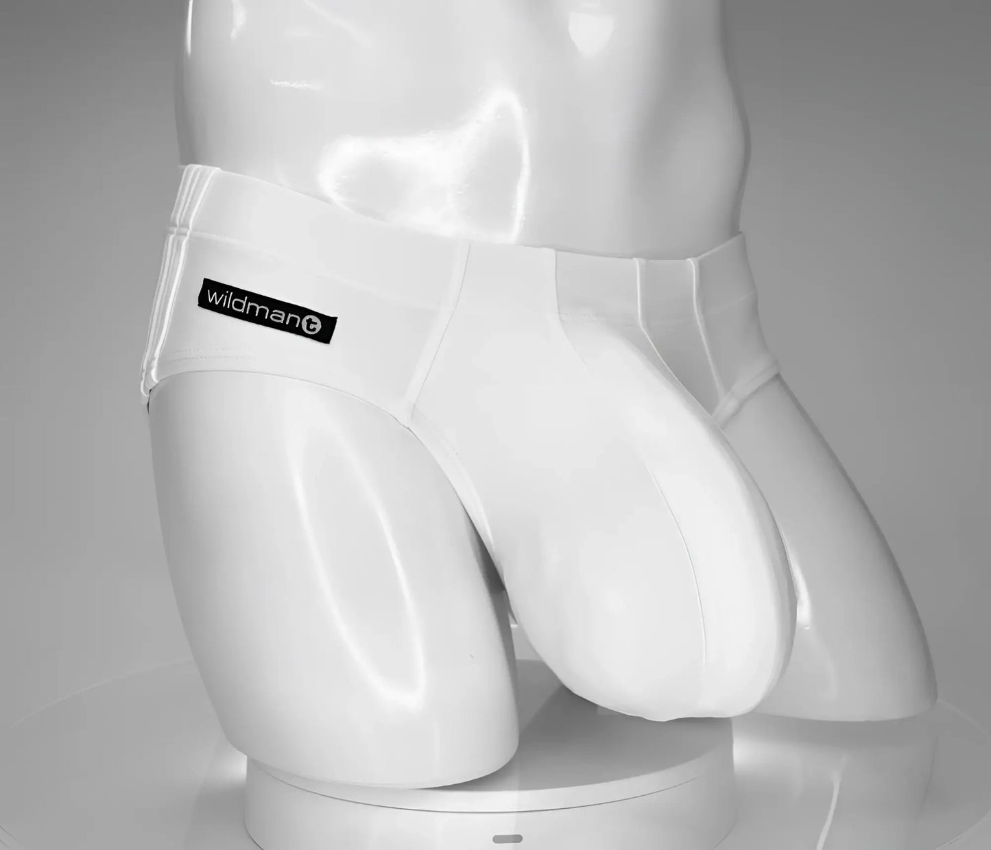 White plastic swim briefs with a black wildman logo patch on the waistband from wildmant monster cock line