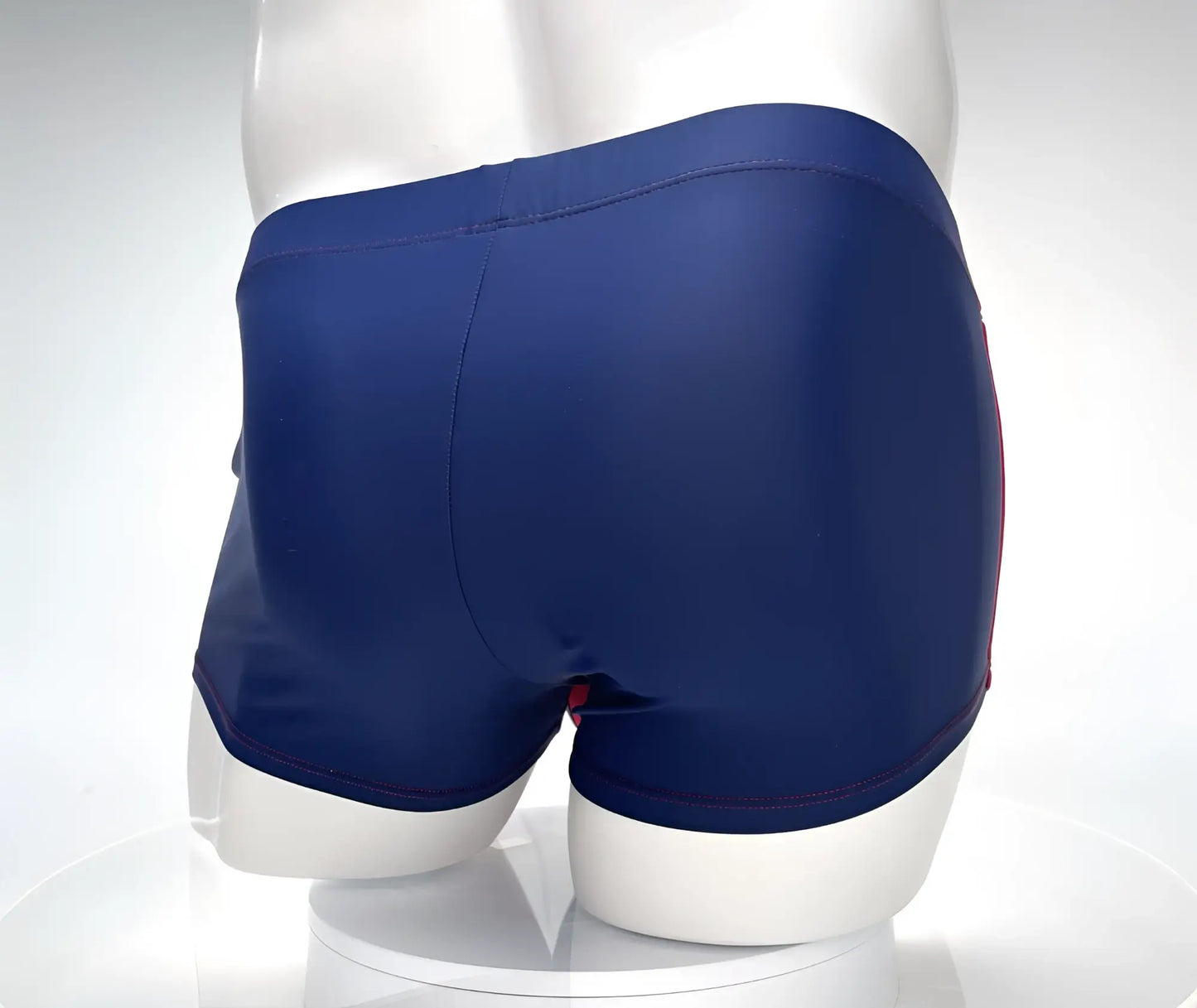 Navy blue WildmanT Monster Cock swim square cut trunks with red trim along the side seams for swimming