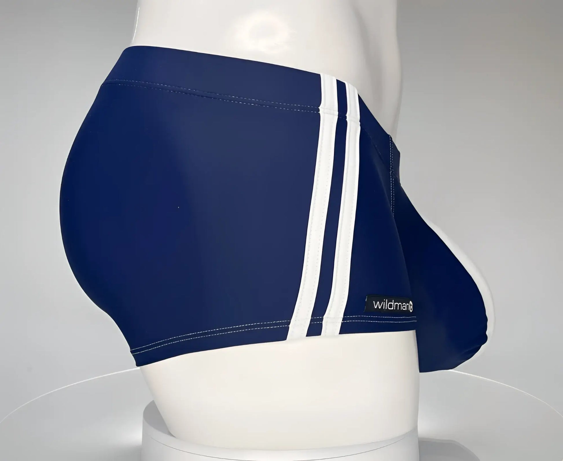 Navy blue WildmanT Monster Cock swim briefs with three white stripes and a brand label in square cut style