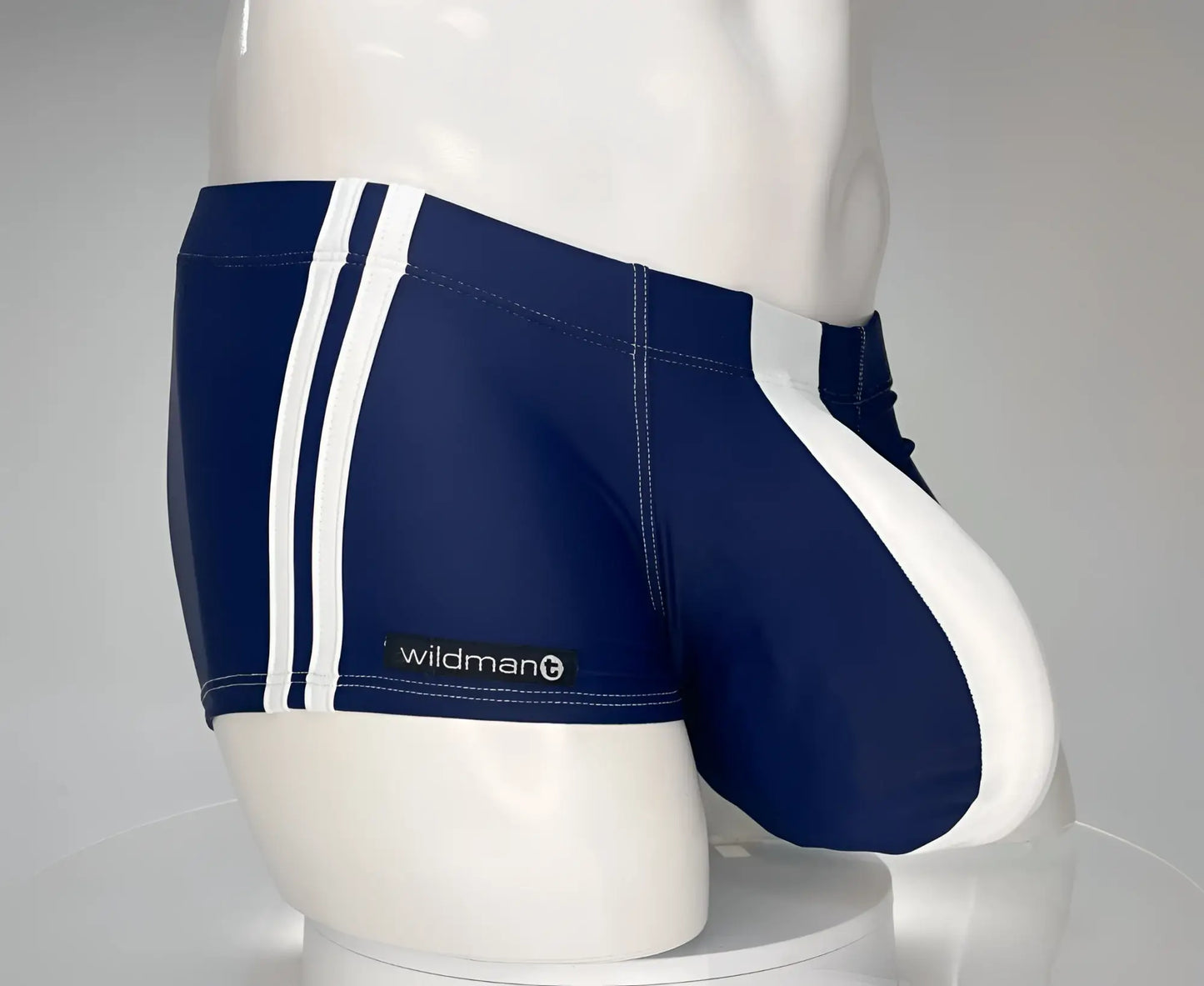Navy blue swim square cut trunks with white side stripes and wildman logo on waistband for beachwear